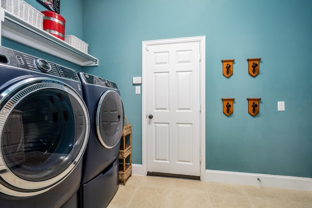 laundry room with washer and dryer and light tile patterned floors