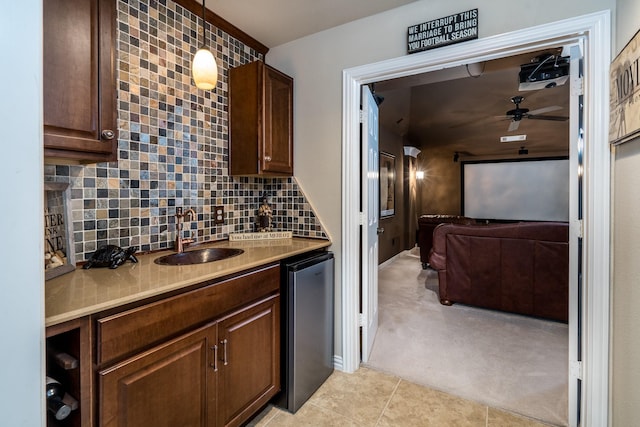 kitchen featuring sink, fridge, pendant lighting, ceiling fan, and backsplash