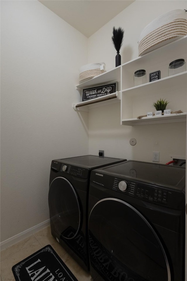 clothes washing area featuring washing machine and clothes dryer and light tile patterned floors