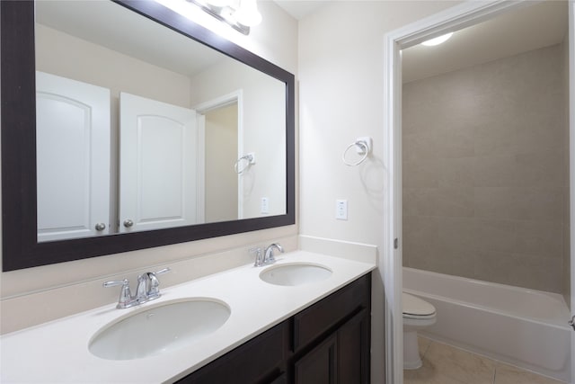 full bathroom with vanity, tiled shower / bath, tile patterned floors, and toilet