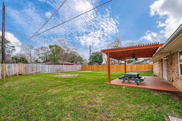 view of yard featuring ceiling fan, a deck, and a pergola