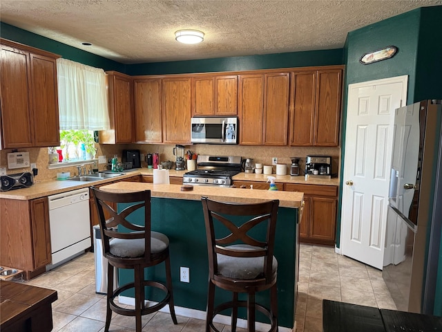 kitchen with tasteful backsplash, a kitchen bar, a kitchen island, and appliances with stainless steel finishes