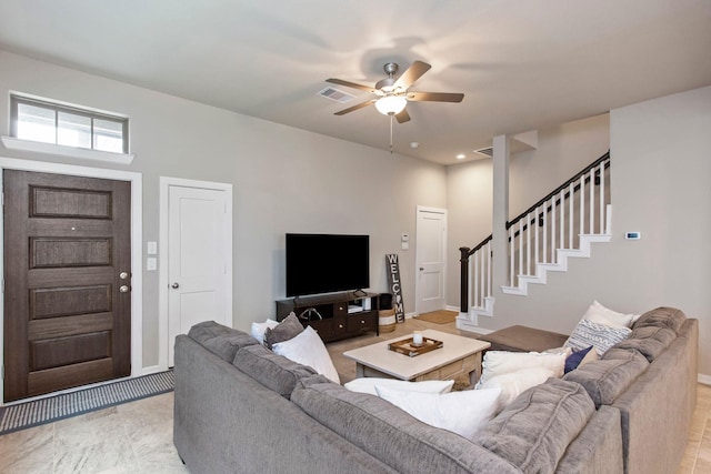 living area with ceiling fan, visible vents, and stairway