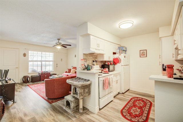 kitchen with light countertops, backsplash, light wood-type flooring, white appliances, and under cabinet range hood