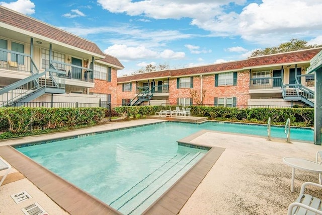 community pool featuring fence and a patio