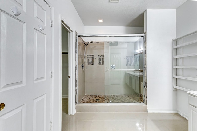 bathroom with vanity, an enclosed shower, and tile patterned floors