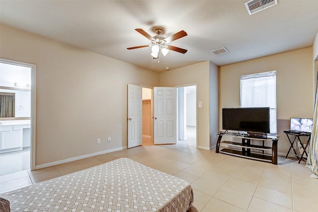 bedroom featuring light tile patterned floors, ensuite bath, and ceiling fan