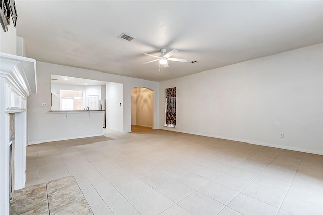 unfurnished living room featuring ceiling fan and light tile patterned floors