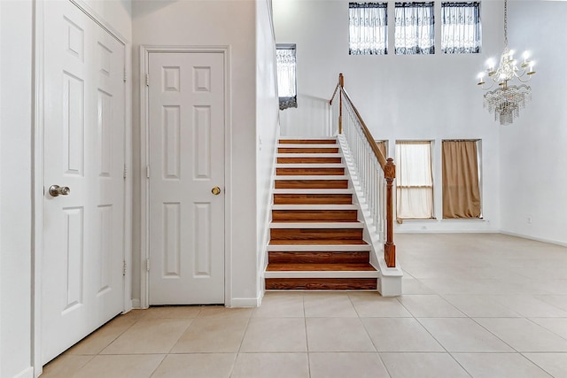 stairs with tile patterned flooring and a chandelier