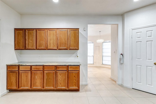 kitchen featuring light tile patterned floors and light stone countertops