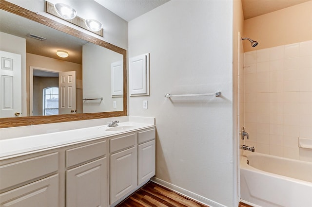 bathroom with hardwood / wood-style flooring, shower / washtub combination, and vanity