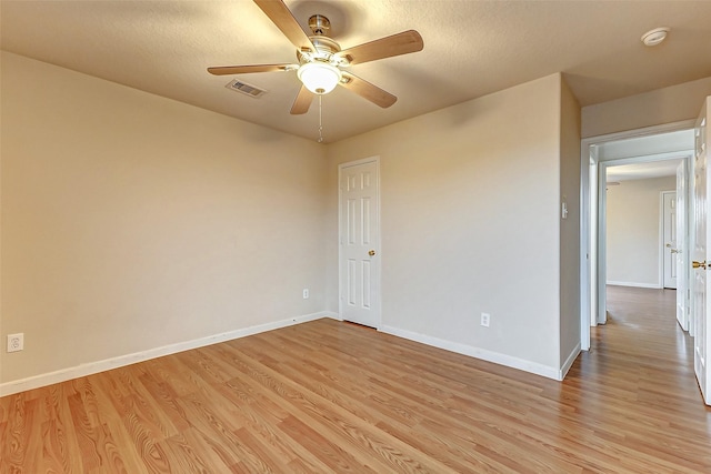 spare room featuring a textured ceiling, light hardwood / wood-style flooring, and ceiling fan