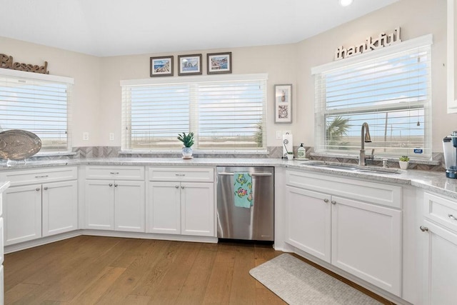 kitchen with sink, stainless steel dishwasher, white cabinets, and light hardwood / wood-style floors