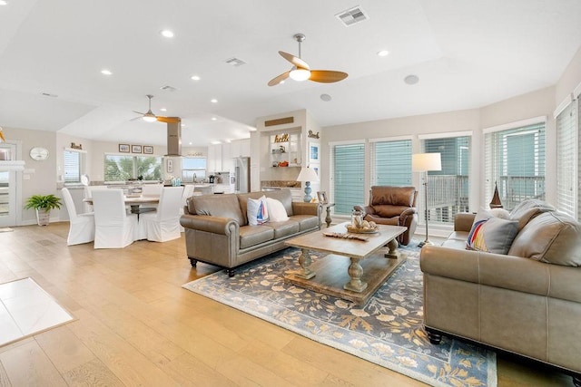 living room featuring ceiling fan, light hardwood / wood-style flooring, and lofted ceiling