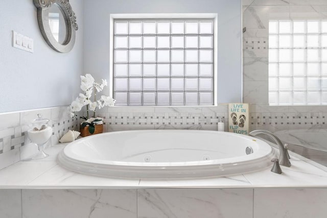 bathroom with tiled bath and plenty of natural light