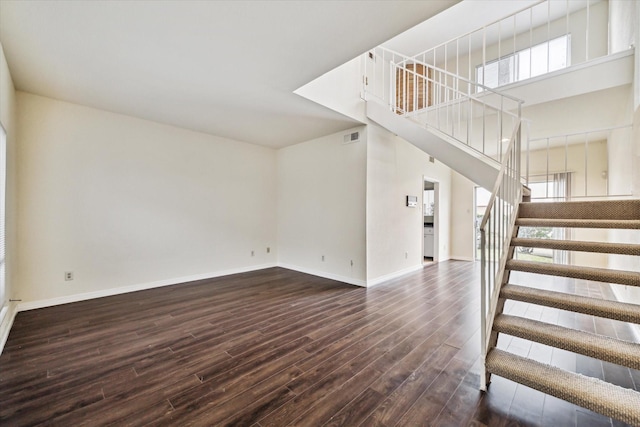 interior space featuring a high ceiling, wood-type flooring, and a wealth of natural light