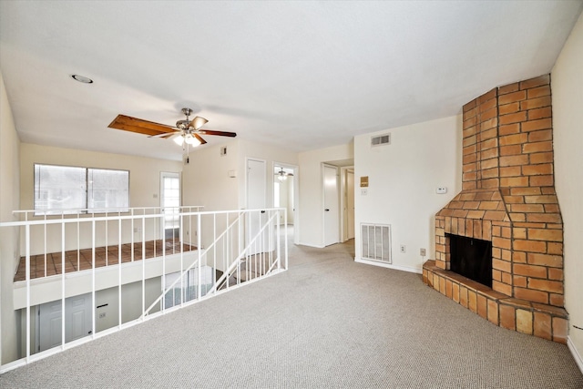 interior space featuring ceiling fan, carpet flooring, and a brick fireplace