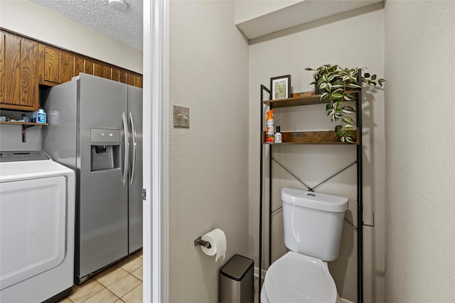 interior space featuring washer / clothes dryer, tile patterned flooring, a textured ceiling, and toilet