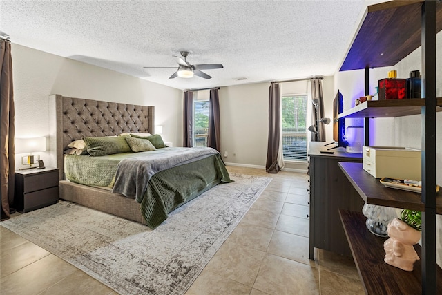 bedroom with ceiling fan, light tile patterned floors, and a textured ceiling