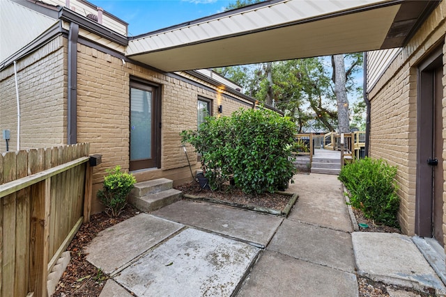 view of exterior entry with a patio area