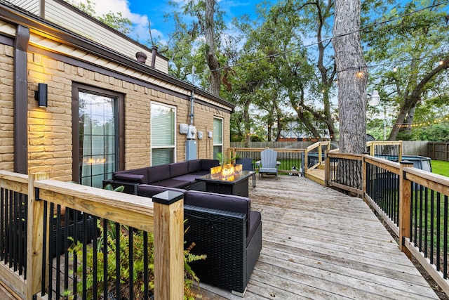 deck featuring an outdoor living space with a fire pit