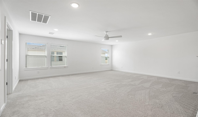 empty room featuring ceiling fan and light colored carpet