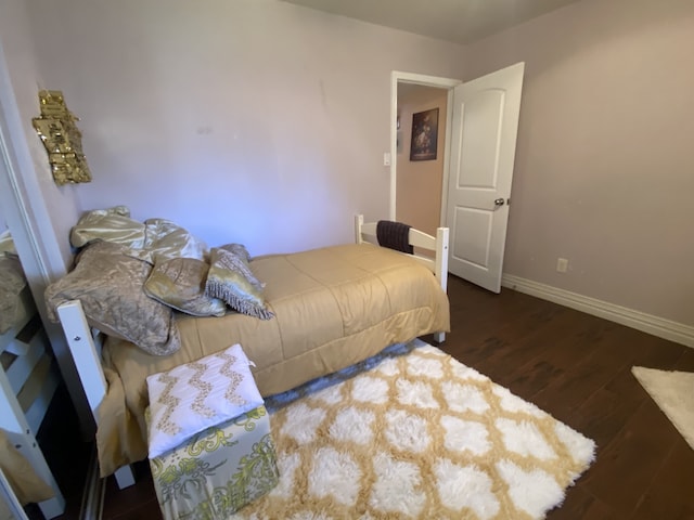 bedroom with dark wood-type flooring