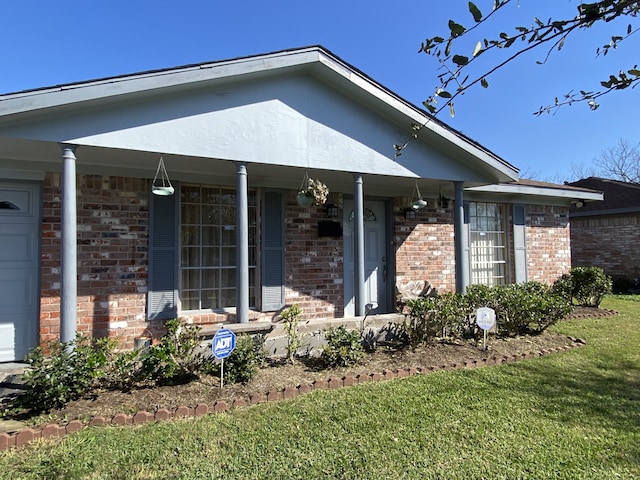 view of front of property featuring a garage, a front yard, and a porch