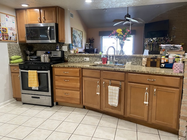 kitchen with lofted ceiling, sink, kitchen peninsula, and appliances with stainless steel finishes