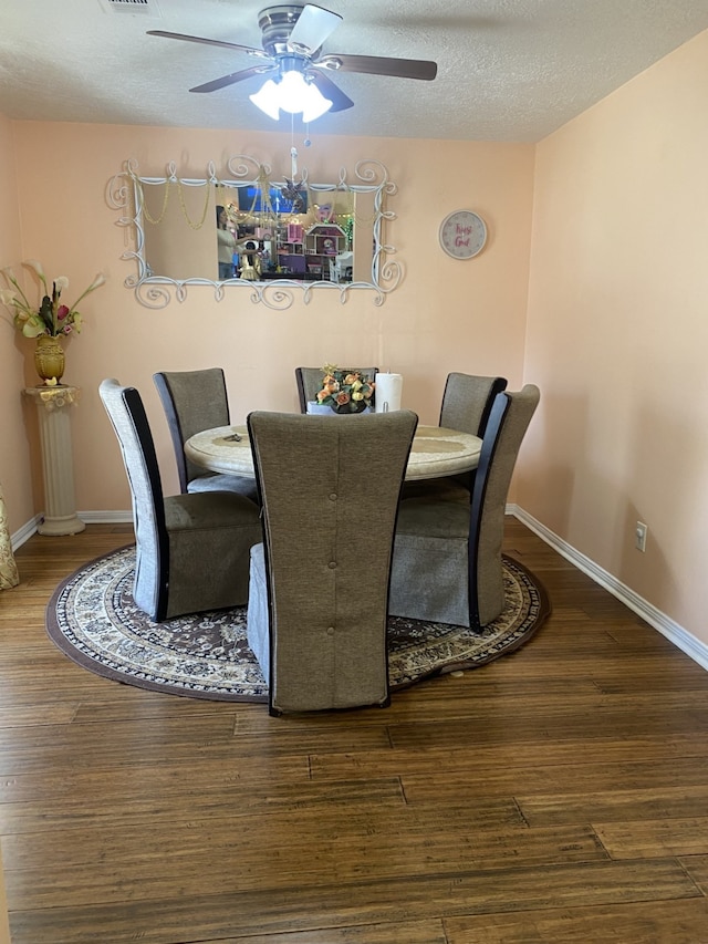 dining space featuring ceiling fan, wood-type flooring, and a textured ceiling