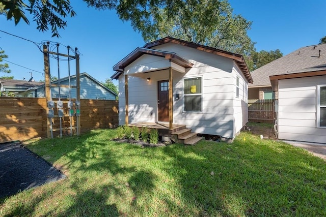 rear view of property featuring a lawn