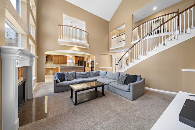 living room with a towering ceiling and carpet floors