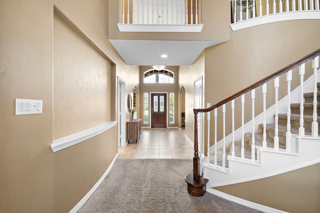 foyer with light carpet and a high ceiling