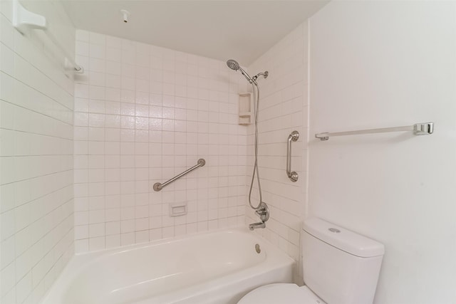 bathroom featuring tiled shower / bath and toilet