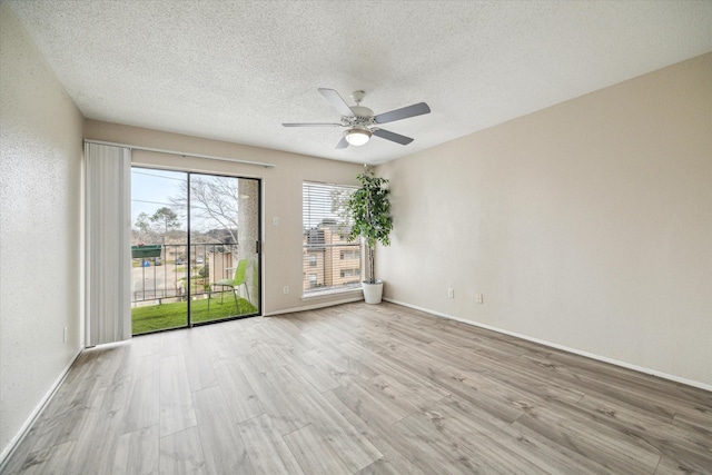 unfurnished room featuring a textured ceiling, wood finished floors, a ceiling fan, and baseboards