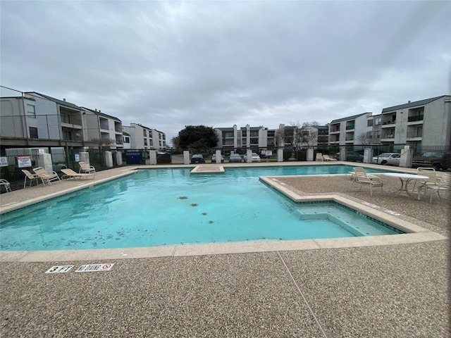 pool with a patio and fence