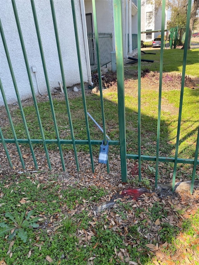 view of gate featuring a lawn and fence