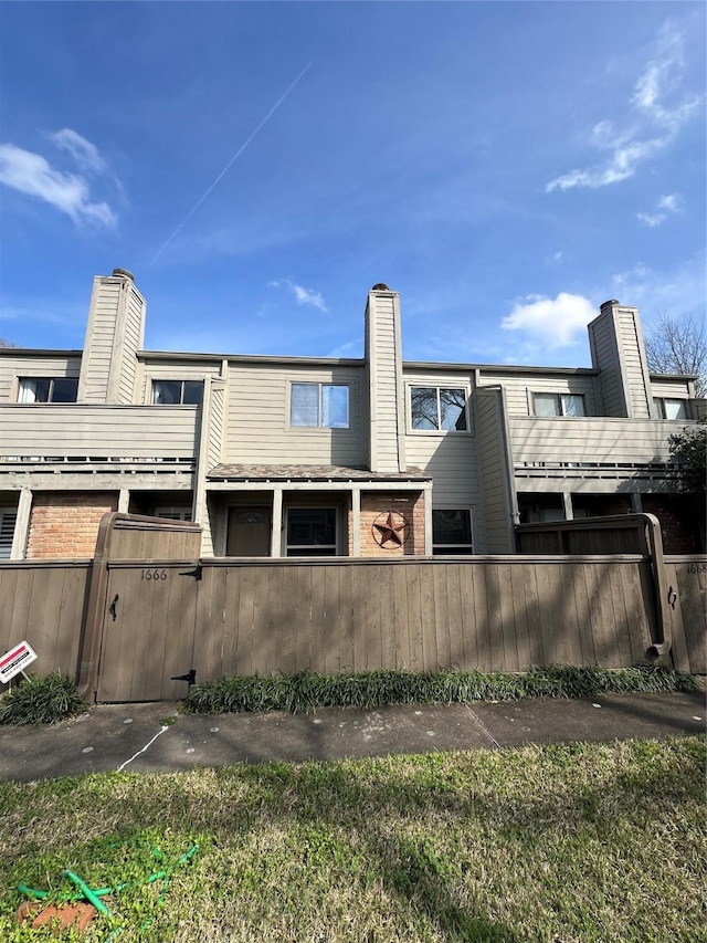 rear view of property with a fenced front yard and a chimney