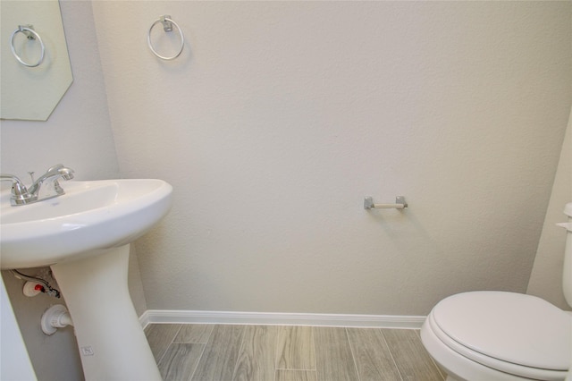 bathroom with wood-type flooring and toilet