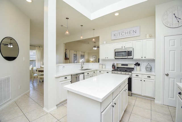 kitchen with stainless steel appliances, light countertops, visible vents, backsplash, and a sink