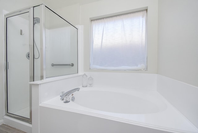 bathroom featuring a garden tub and a shower stall