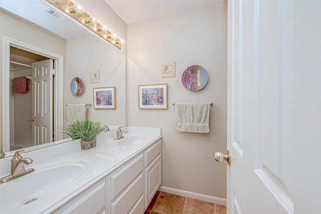 bathroom featuring visible vents, a sink, baseboards, and double vanity