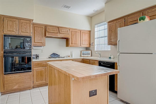 kitchen with visible vents, butcher block countertops, black appliances, a sink, and light tile patterned flooring