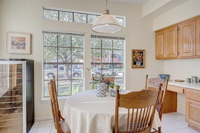 dining space featuring a healthy amount of sunlight, built in study area, beverage cooler, and light tile patterned floors