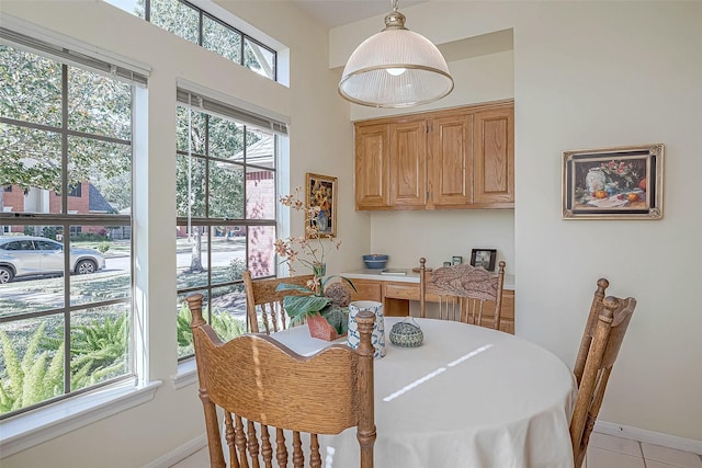 dining room featuring baseboards and light tile patterned floors