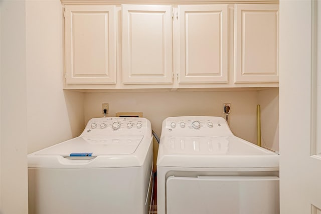 clothes washing area with cabinet space and separate washer and dryer