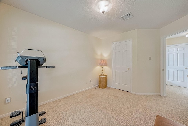 workout room featuring carpet floors, baseboards, visible vents, and a textured ceiling