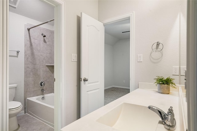 full bathroom featuring tile patterned flooring, tiled shower / bath, vanity, and toilet