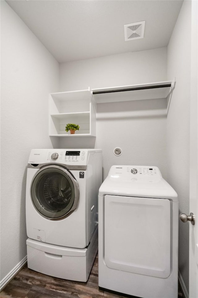 washroom with dark hardwood / wood-style floors and independent washer and dryer