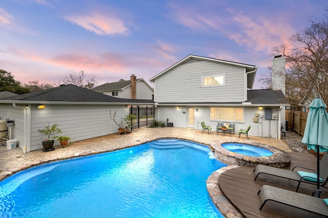 view of pool featuring a patio area, a fenced backyard, a fenced in pool, and an in ground hot tub